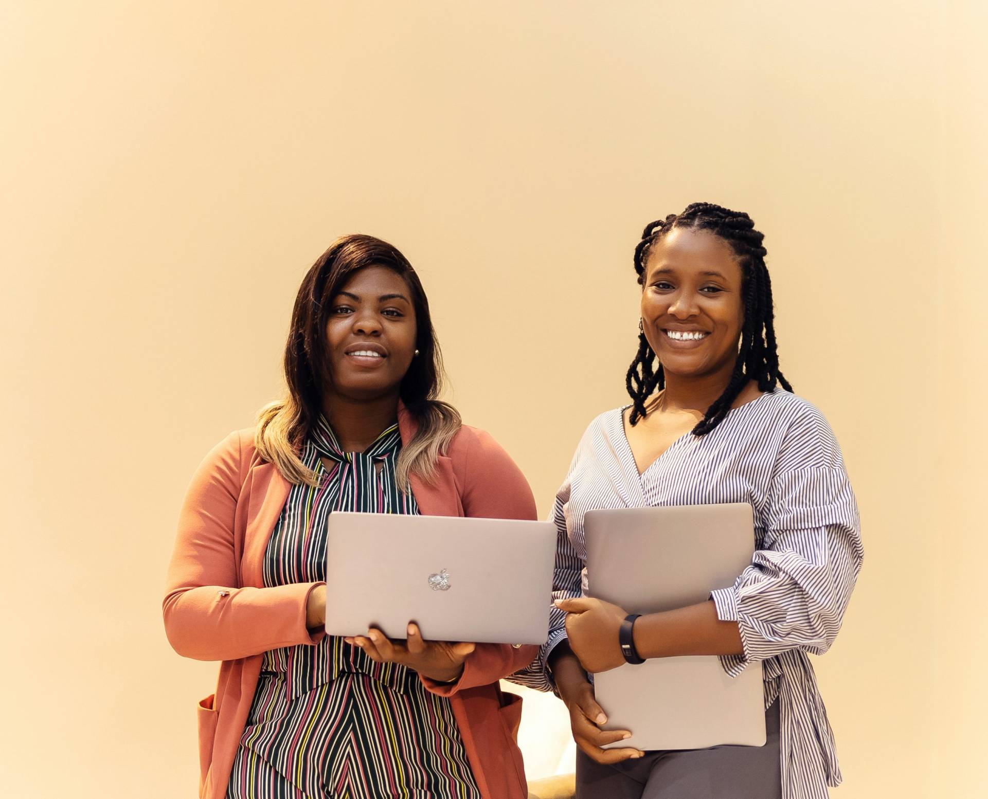 Two women holding laptops